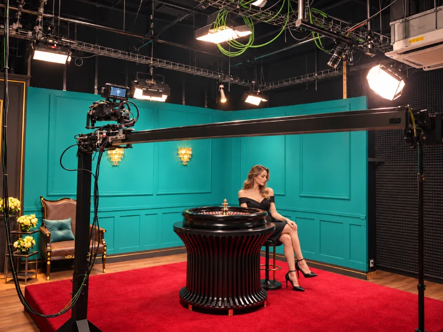 Dealer at a roulette table in a teal studio