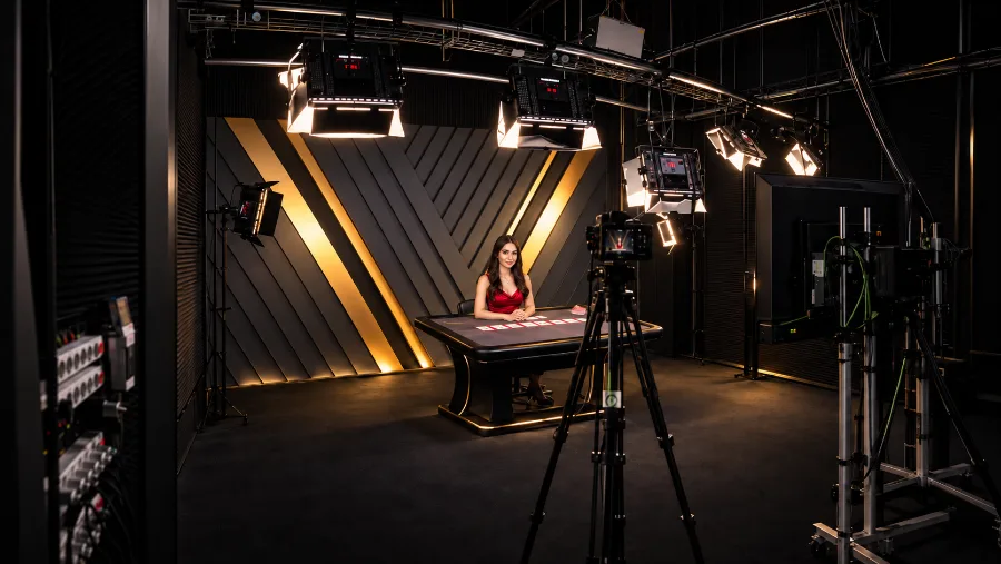 Dealer at a card table in a dark studio